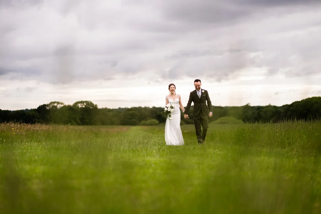 bride and groom walking in the field at Beeston Manor